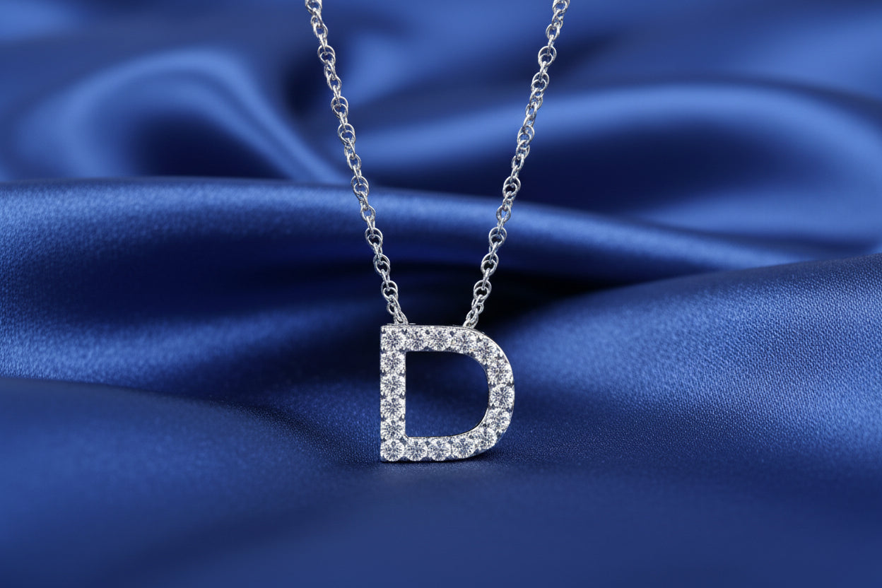 Silver necklace with a 'D' pendant on a white background